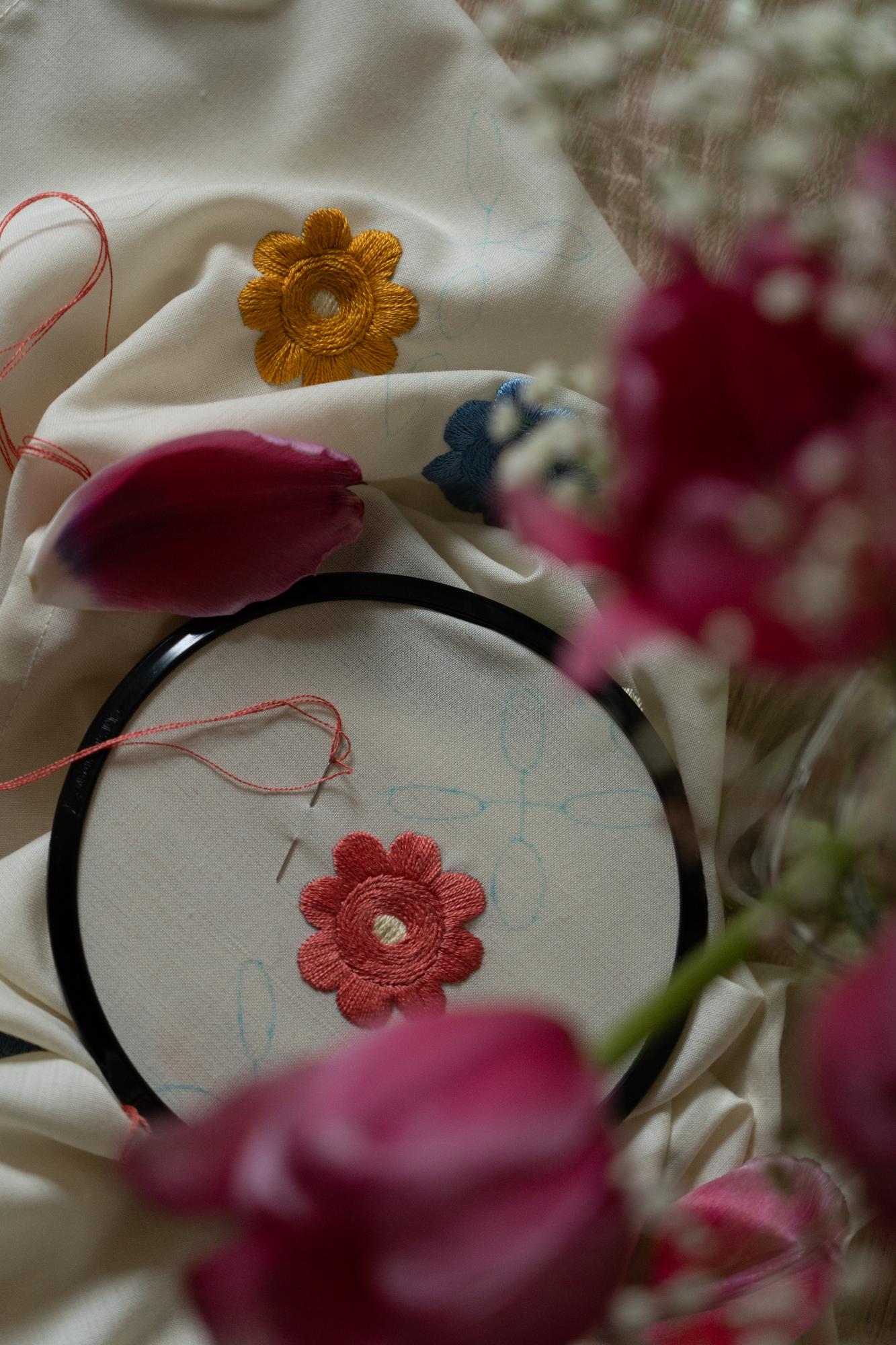 Close-up of embroidered floral hoop on linen